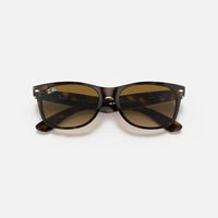 Ray-Ban New Wayfarer RB2132 sunglasses with glossy tortoiseshell frame and brown G-15 lenses, UV400 protection.